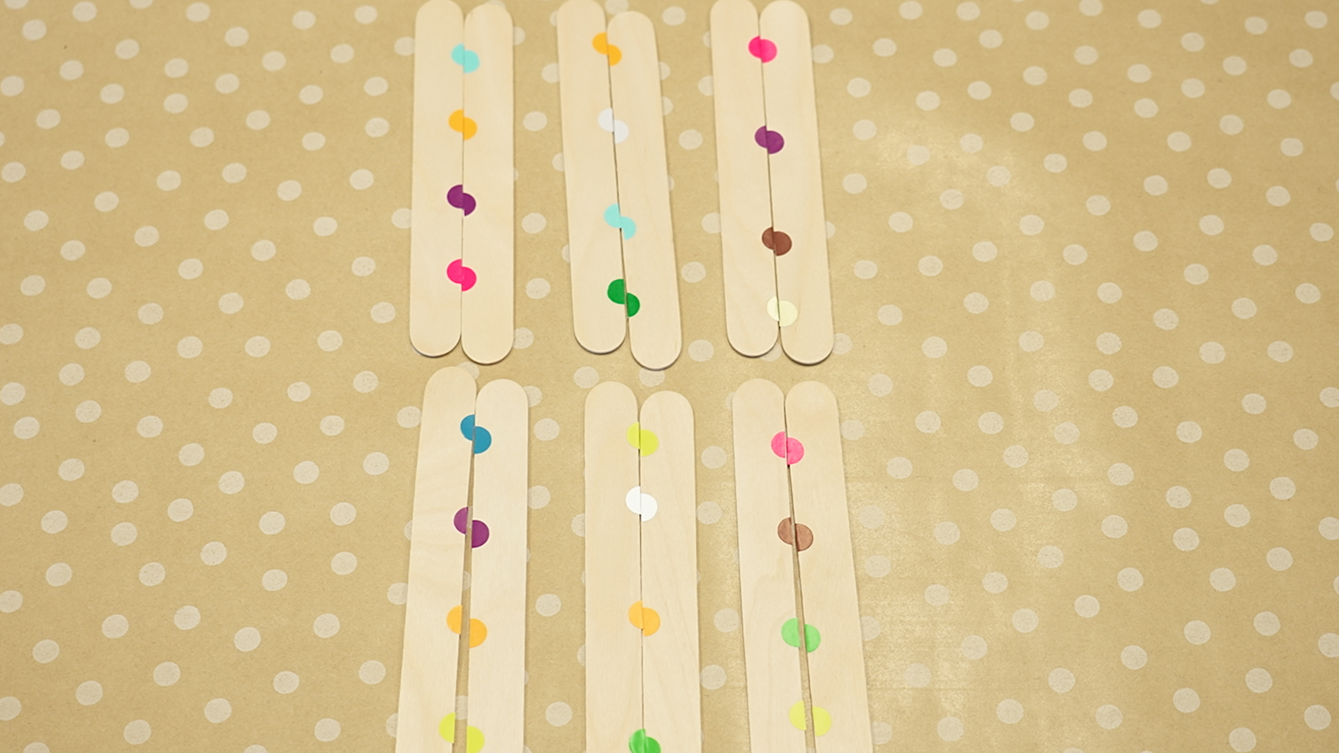 lolly sticks with coloured dots on a table