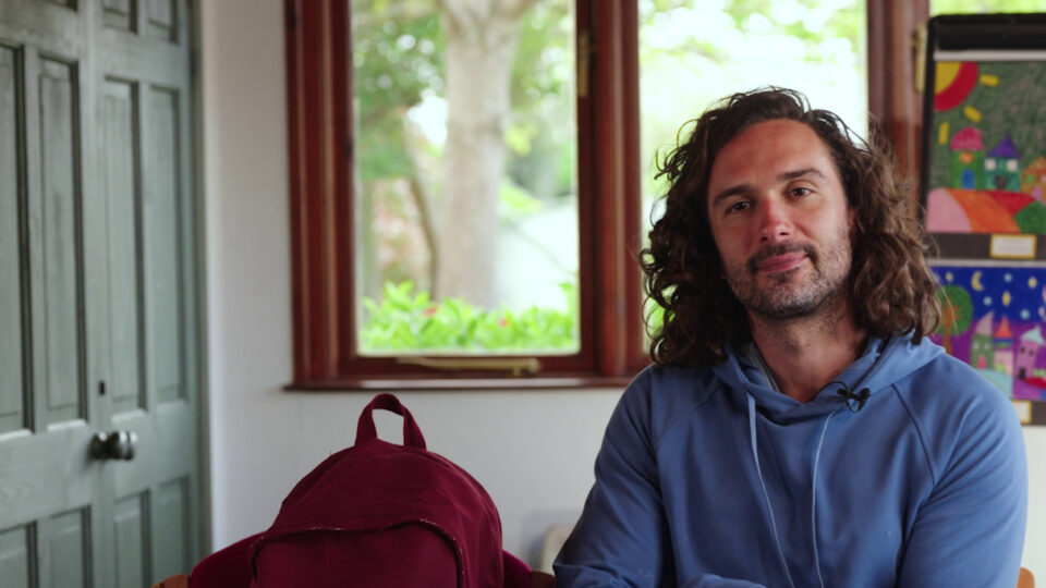 Joe Wicks next to a large red rucksack