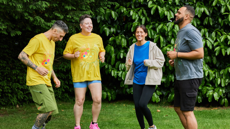 four people in Children in Need t-shirts and sports wear running on the spot