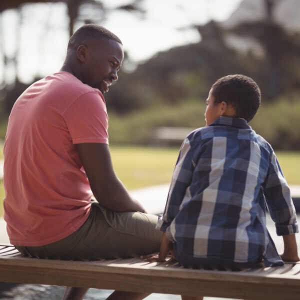 A child and adult sit together on a bench