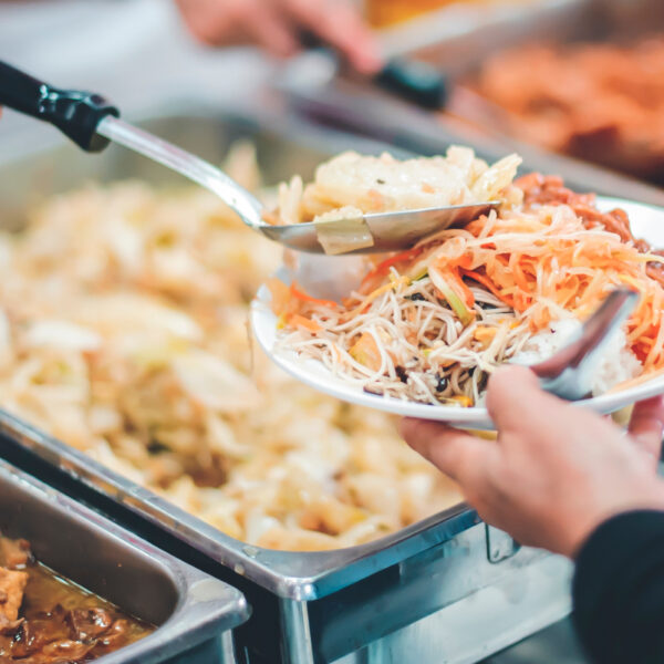 A child being served food from a large metal tray