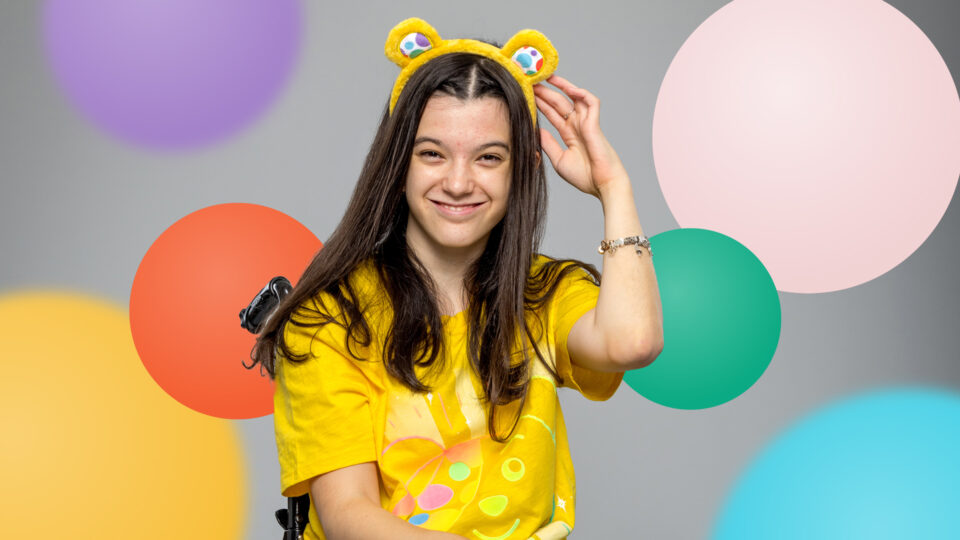 Emily smiling against a spotty background wearing Pudsey ears and a Pudsey t-shirt