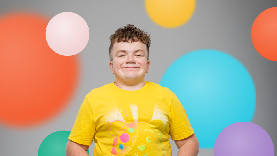 Ethan smiling against a spotty background wearing Pudsey ears and a Pudsey t-shirt