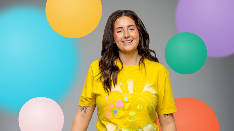 Grace smiling against a spotty background wearing Pudsey ears and a Pudsey t-shirt