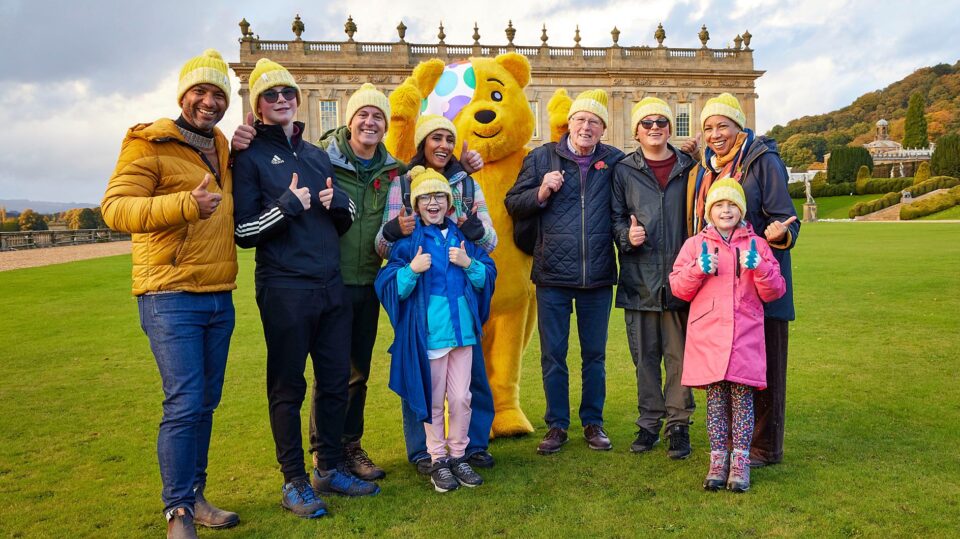 L-R: Sean Fletcher, Lucas, Matt Baker MBE, Rubi, Anita Rani, Pudsey, John Craven, Jack, Margherita Taylor, and Sophie pose outside Chatsworth House, Peak District, after completing their rambles (Image: BBC Studios/BBC Children In Need/Neil Sherwood)