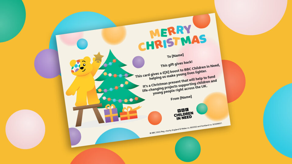 Merry Christmas gift voucher with Pudsey putting a star on a Christmas tree