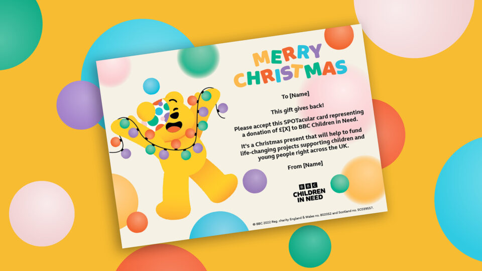 Merry Christmas gift voucher with spots and Pudsey holding up Christmas lights