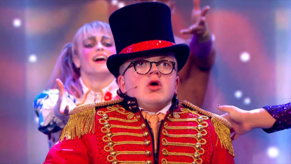 Ethan performing in a red jacket and top hat