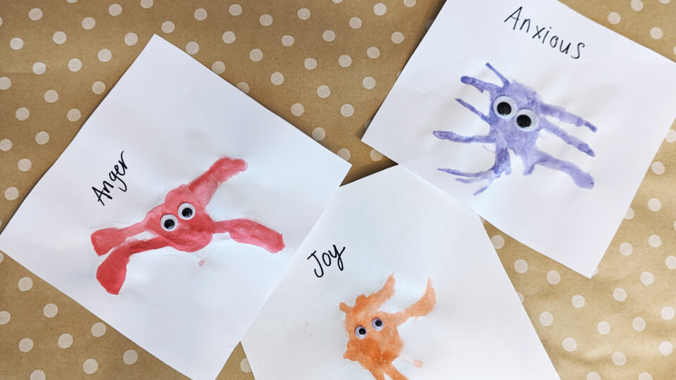 Watercolour monsters showing anger as a red splodge, anxious as a purple splodge and joy as an orange splodge