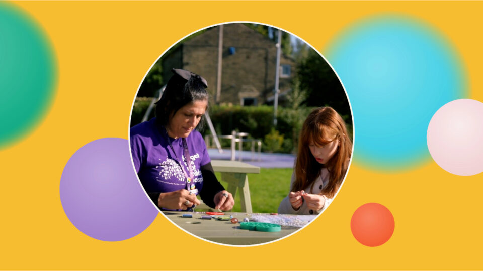 A child and grown up crafting at a table outside